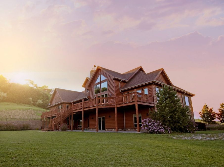 brown wooden house with green grass field